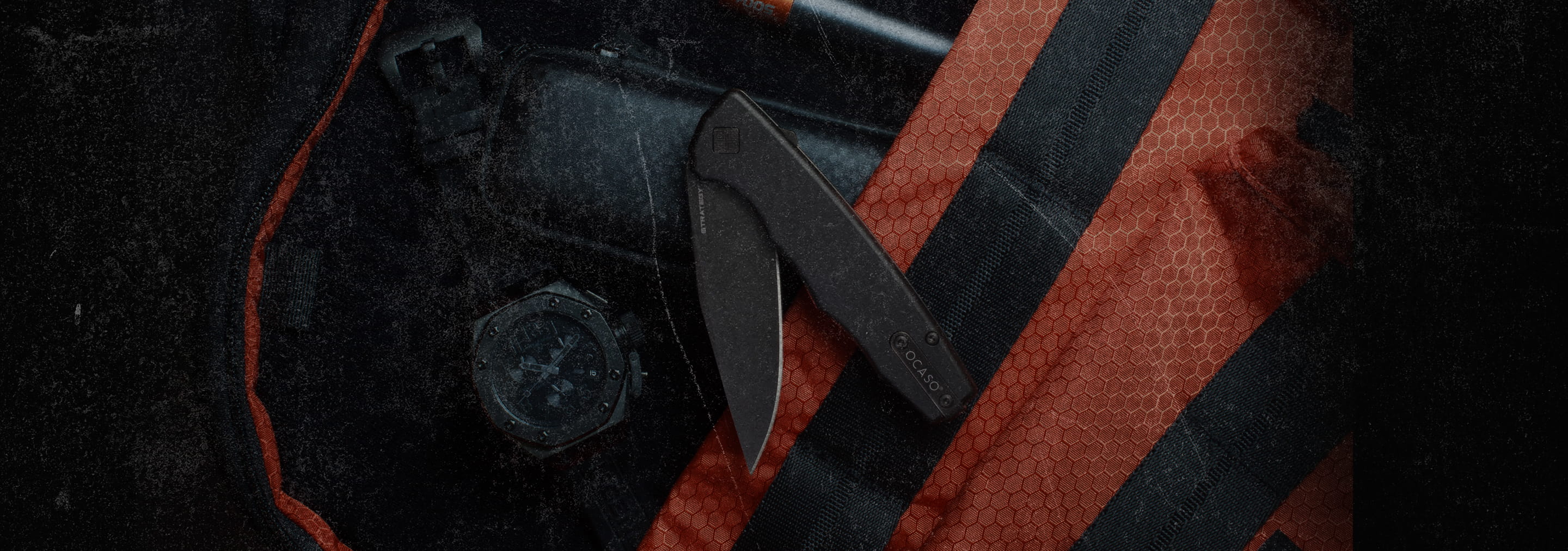 Close-up of a knife with a black handle and blade on a textured surface.